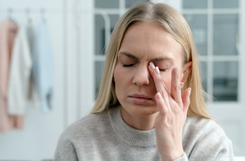 person with eyes closed and hand up near them dealing with dry eye